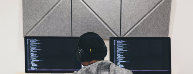 Focused programmer working diligently on coding project at a computer workstation.